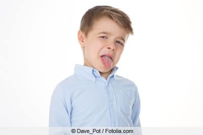 Angewidertes Kind streckt Zunge raus