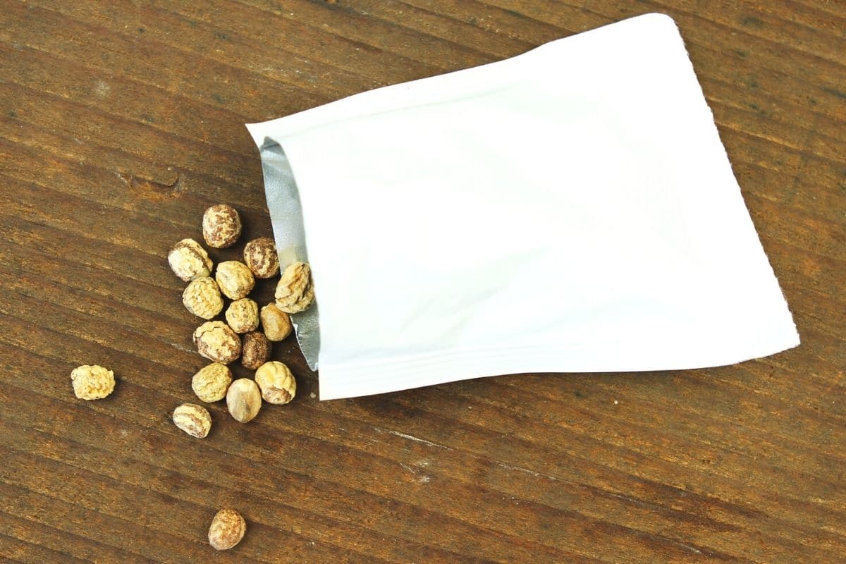Samen der Kapuzinerkresse in kleiner Papiertüte auf Tisch